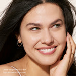 Close-up of a woman with a soft smile, wearing minimal makeup. [5.0 EP]