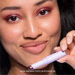 Woman holding a makeup product with text overlay [Studio 28]