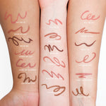 Swatches of Tower 28 Beauty’s OneLiner Lip Liner shades are shown on three different skin tones. Each arm displays the full range: Fill Me In, Work of Art, Draw Me, Check Me Out, Paint My Number, and Color Me Fine. [Shared]