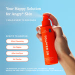 Orange spray bottle labeled 'Tower 28' held by a hand against a blue sky background [Shared]